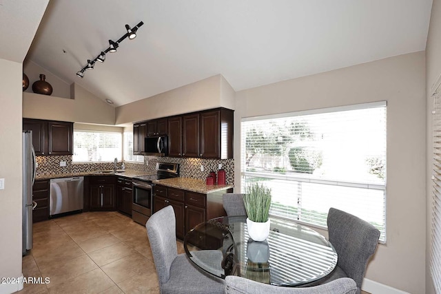 kitchen with sink, stainless steel appliances, tasteful backsplash, lofted ceiling, and dark brown cabinets