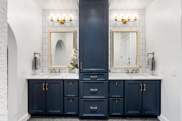 full bathroom featuring two vanities, baseboards, and a sink