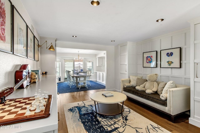 living area featuring recessed lighting, a notable chandelier, and wood finished floors