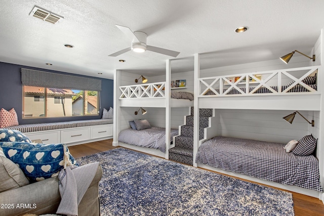 bedroom featuring wood finished floors, visible vents, and a textured ceiling