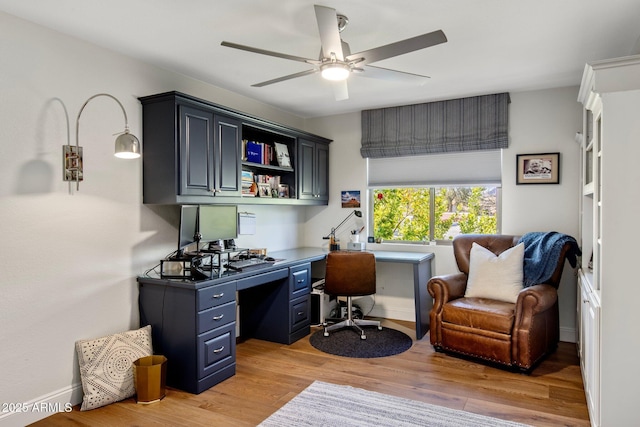 office space with baseboards, light wood-type flooring, and a ceiling fan