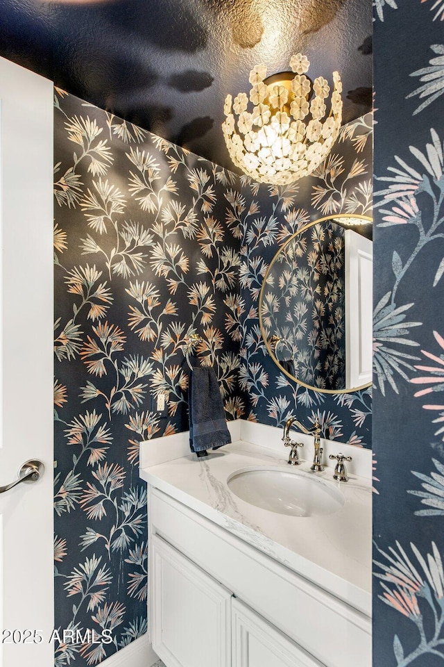 bathroom with vanity and wallpapered walls