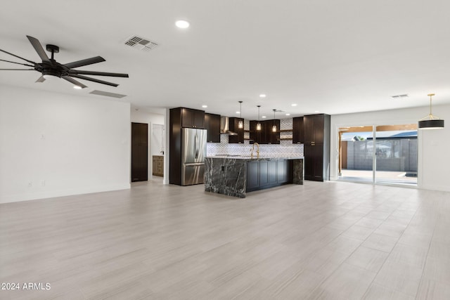 unfurnished living room featuring ceiling fan, light wood-type flooring, and sink