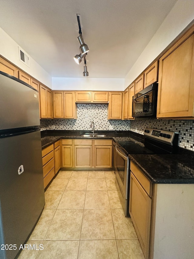 1702 W Tuckey Ln Unit 116, Phoenix, AZ 85015 - kitchen with appliances with stainless steel finishes, light tile patterned floors, decorative backsplash, and brown cabinets