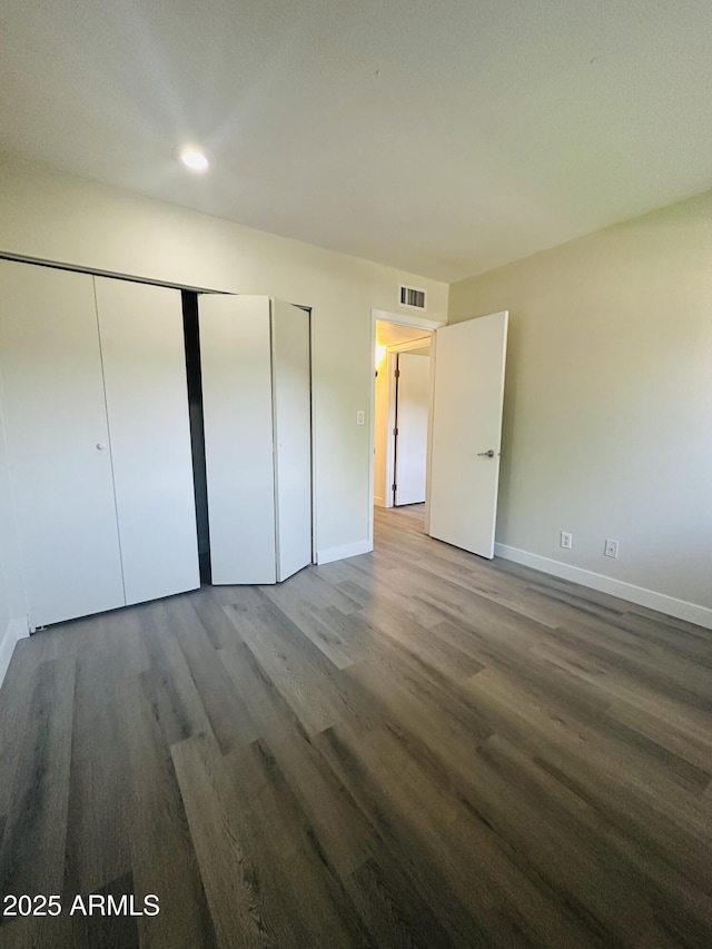 1702 W Tuckey Ln Unit 116, Phoenix, AZ 85015 - unfurnished bedroom featuring wood finished floors, a closet, and recessed lighting