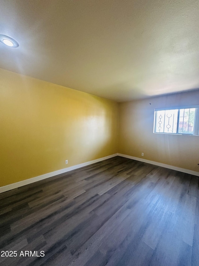 1702 W Tuckey Ln Unit 116, Phoenix, AZ 85015 - spare room with baseboards and dark wood finished floors