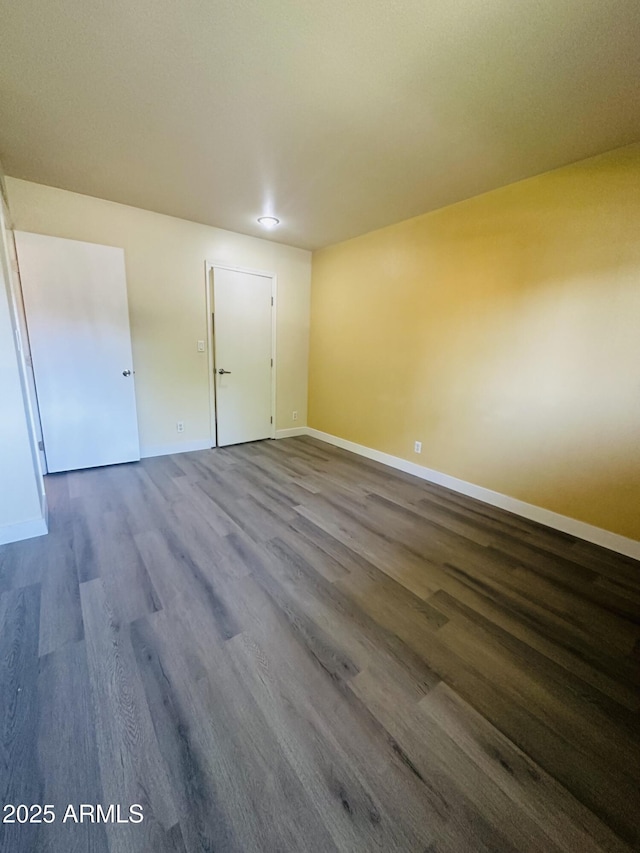 1702 W Tuckey Ln Unit 116, Phoenix, AZ 85015 - unfurnished bedroom with dark wood-style floors and baseboards
