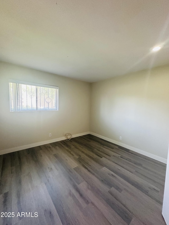 1702 W Tuckey Ln Unit 116, Phoenix, AZ 85015 - unfurnished room with dark wood-type flooring and baseboards