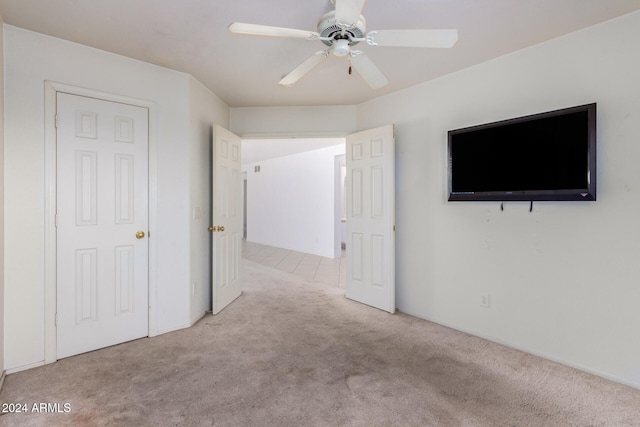 unfurnished bedroom featuring light carpet and ceiling fan