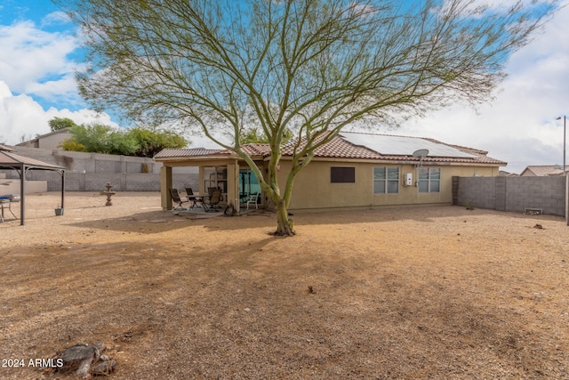 rear view of property featuring a gazebo