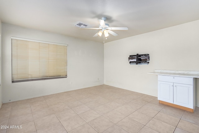 tiled spare room featuring ceiling fan