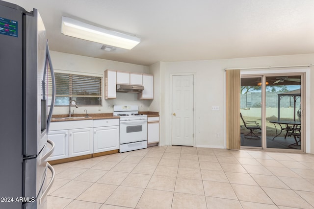 kitchen featuring white cabinetry, stainless steel refrigerator, white range with gas cooktop, and sink