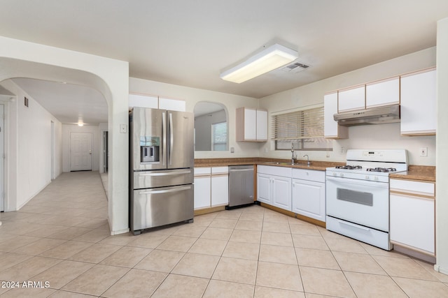 kitchen featuring white cabinetry, sink, light tile patterned flooring, and stainless steel appliances