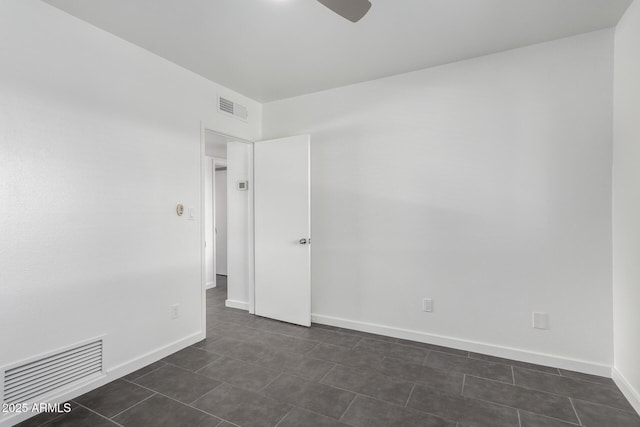 spare room featuring a ceiling fan, baseboards, and visible vents