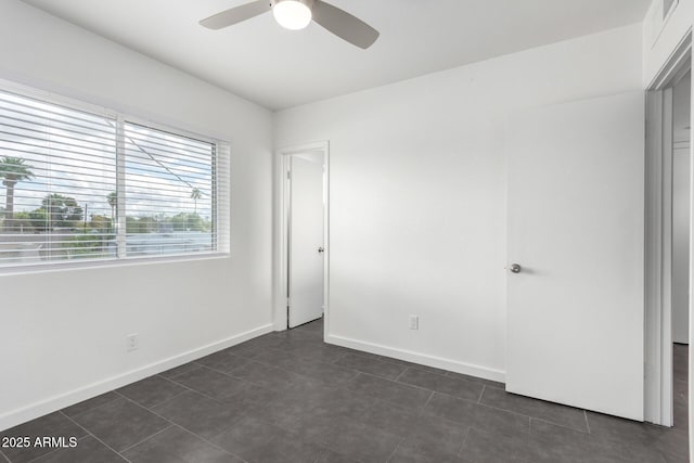 unfurnished bedroom featuring a ceiling fan and baseboards