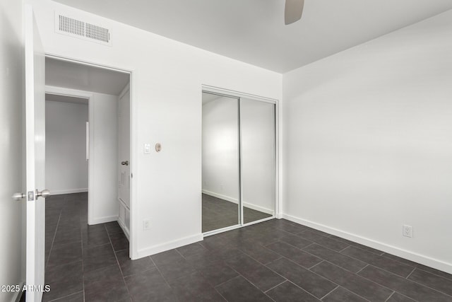 unfurnished bedroom featuring a closet, visible vents, ceiling fan, and baseboards