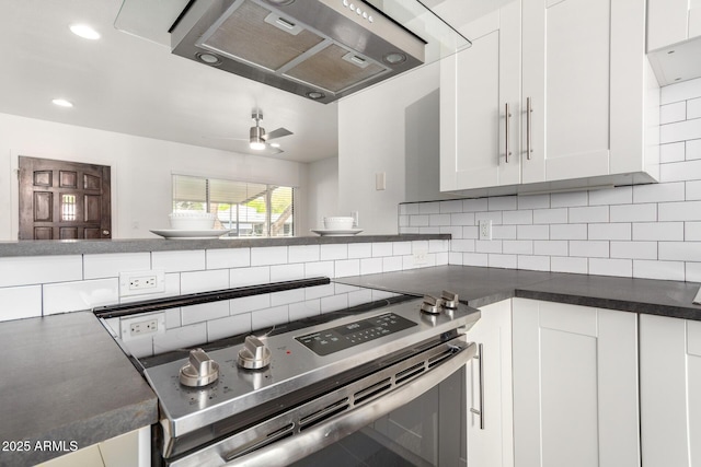 kitchen with range hood, dark countertops, stainless steel electric range, and backsplash