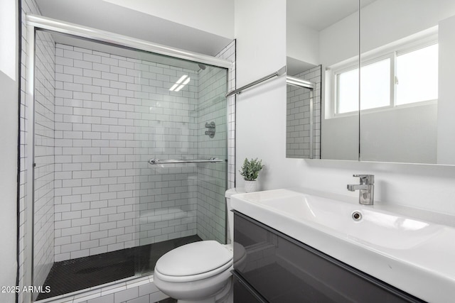 bathroom with a stall shower, toilet, and vanity