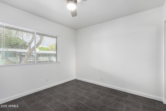 empty room with ceiling fan and baseboards