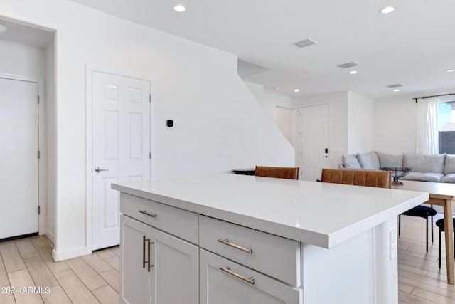 kitchen featuring light hardwood / wood-style floors, a kitchen island, and a breakfast bar area