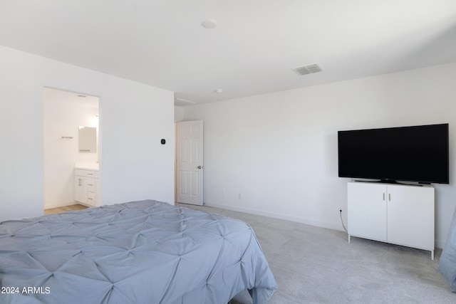 bedroom featuring light carpet and connected bathroom