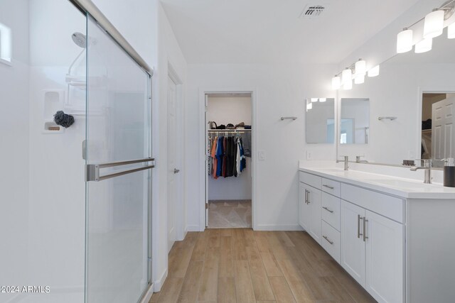 bathroom featuring vanity, hardwood / wood-style floors, and a shower with shower door