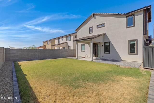 rear view of property with a yard and a patio area