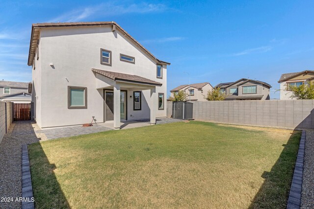 back of house with a lawn and central AC