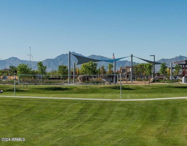 view of community with a lawn, a mountain view, and volleyball court