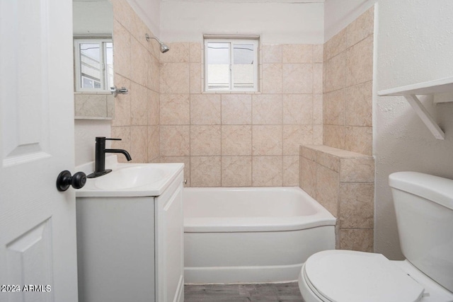 full bathroom with toilet, tiled shower / bath combo, and vanity