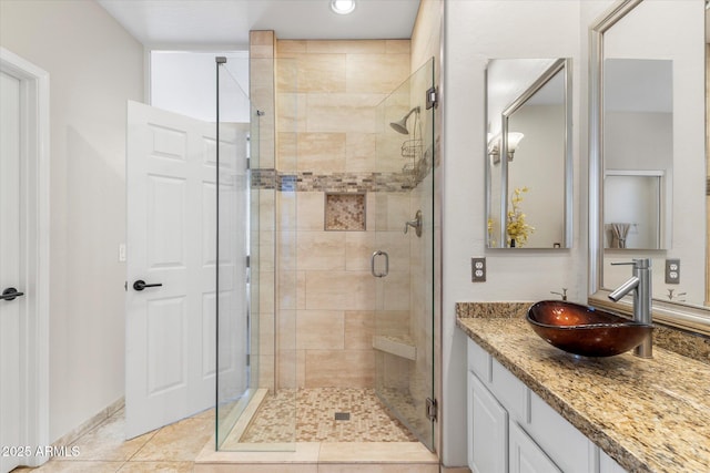 full bath with vanity, a stall shower, and tile patterned flooring