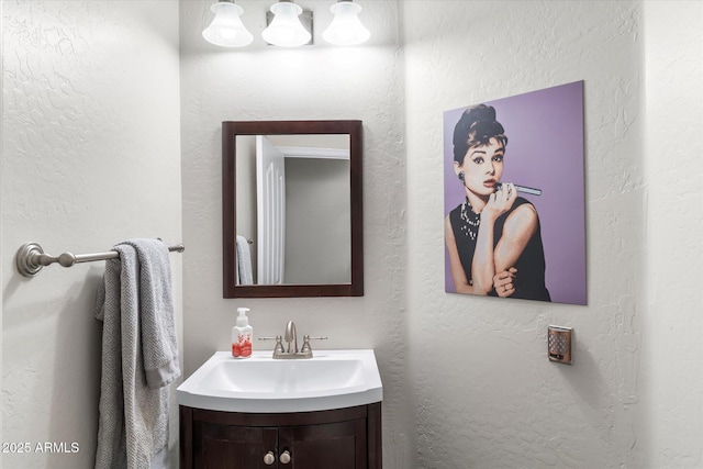 bathroom featuring vanity and a textured wall