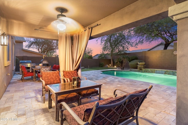 patio terrace at dusk featuring a fenced in pool, outdoor dining area, a fenced backyard, and a ceiling fan