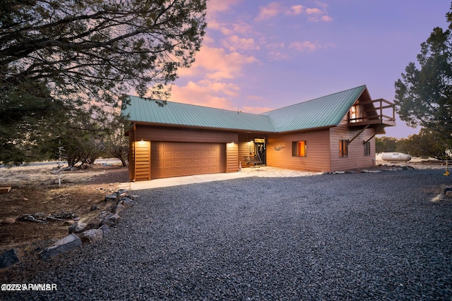 rustic home featuring metal roof, driveway, and an attached garage