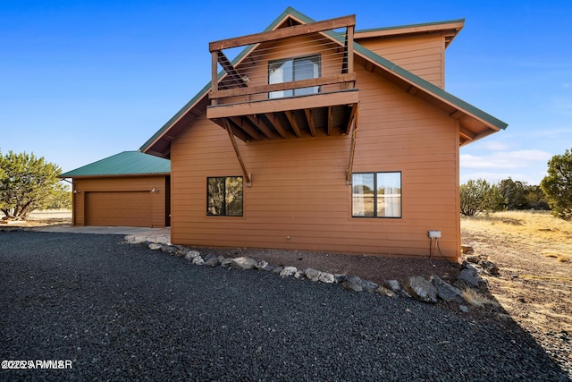 view of home's exterior featuring an attached garage and gravel driveway