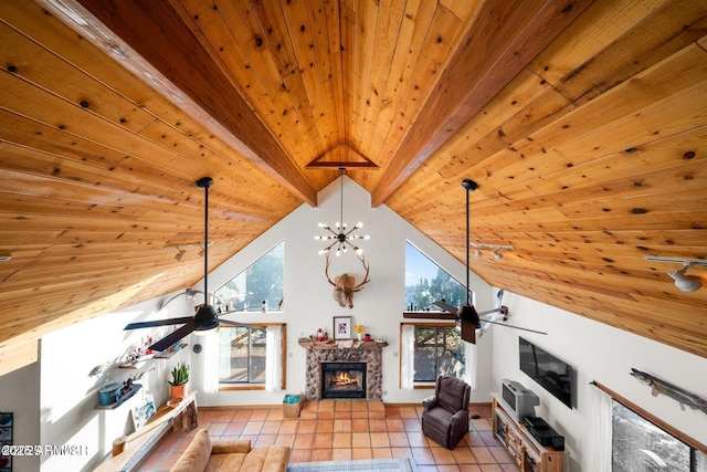 living room with wooden ceiling, ceiling fan, a stone fireplace, and a healthy amount of sunlight