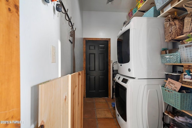 clothes washing area featuring laundry area, tile patterned floors, visible vents, and stacked washer / drying machine