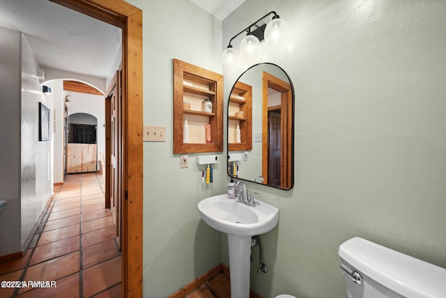 bathroom with toilet, tile patterned floors, and a sink