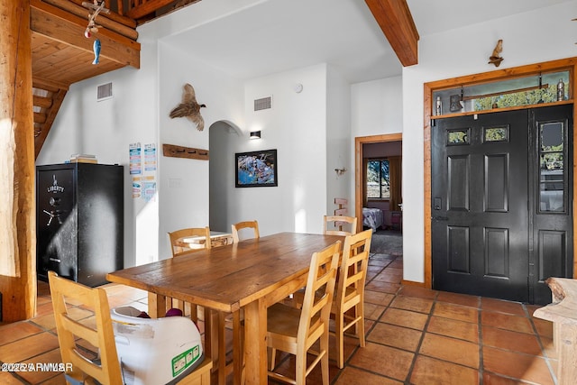 dining space with beam ceiling and visible vents