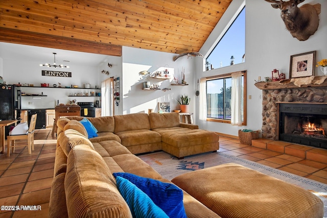 tiled living room with a stone fireplace, high vaulted ceiling, a chandelier, and wood ceiling