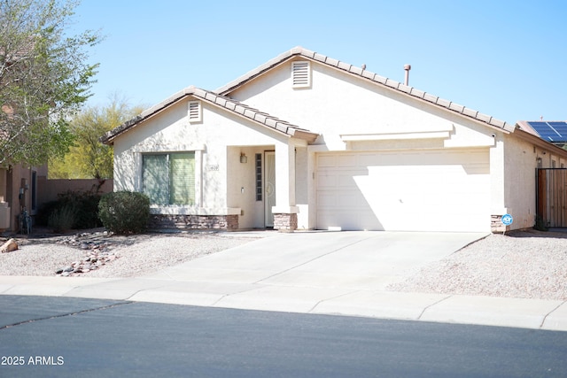 view of front of home with stucco siding, an attached garage, driveway, and fence