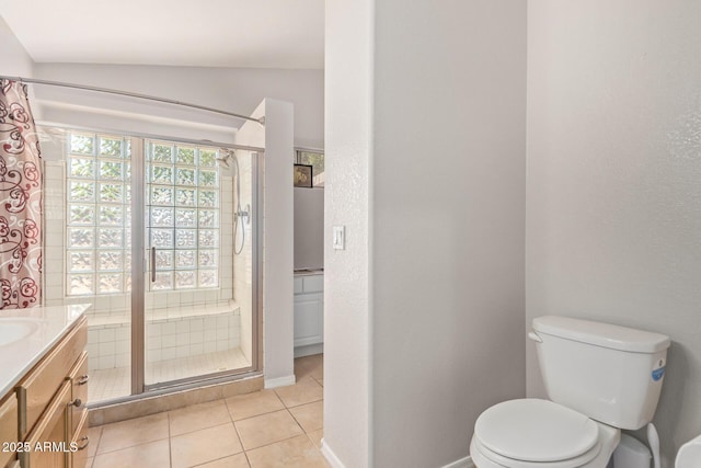 bathroom featuring tile patterned floors, vanity, a tile shower, and toilet