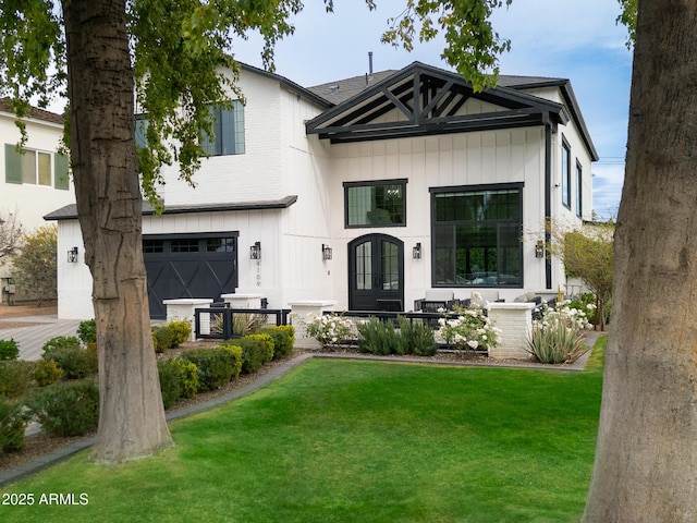 modern farmhouse featuring french doors, board and batten siding, an attached garage, and a front lawn