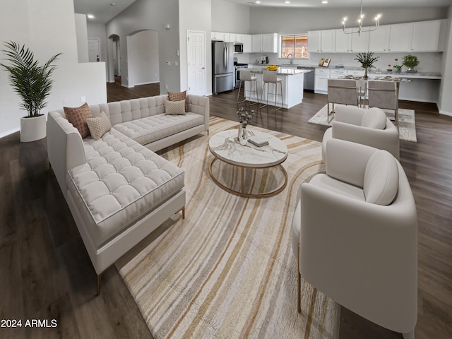 living room with sink, high vaulted ceiling, an inviting chandelier, and hardwood / wood-style flooring