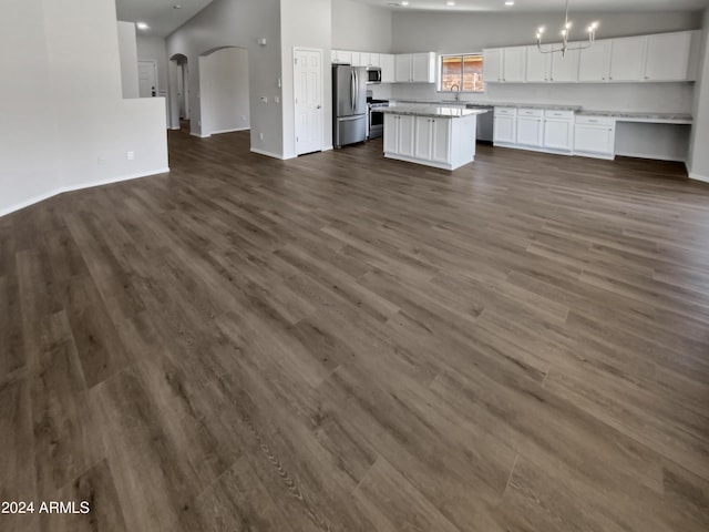 kitchen with appliances with stainless steel finishes, white cabinetry, dark wood-type flooring, and sink