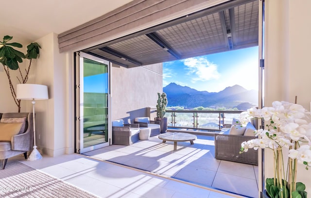 view of patio featuring an outdoor living space, a mountain view, and a balcony