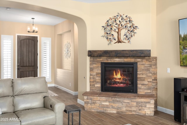 living room with a chandelier, wood finished floors, and baseboards