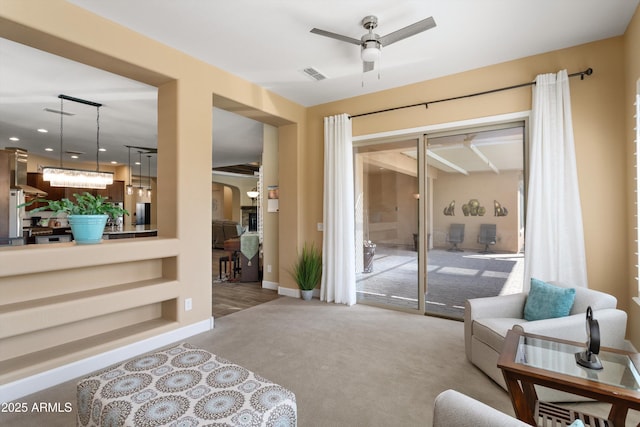 carpeted living area with visible vents, baseboards, built in shelves, ceiling fan, and recessed lighting