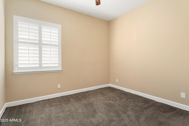 unfurnished room featuring dark carpet, baseboards, and a ceiling fan