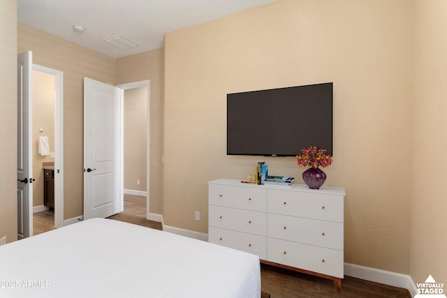 bedroom with visible vents, baseboards, and connected bathroom